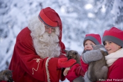 Santa Claus und seine Elfen mit einem jungen Husky